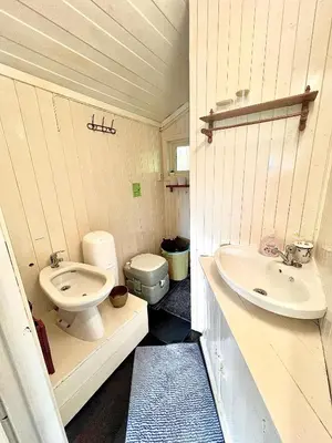 a small bathroom with a sink and a toilet at Cabin at Hestsjøen Badeplass in Trondheim