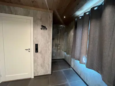 a bathroom with a white door and a walk in shower at Hus nær butikk, sentrum & rekreasjon in Hol