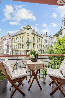 a balcony with a table and chairs and a building at A Gem in the Heart of Ålesund in Ålesund