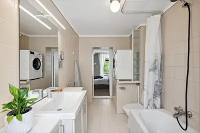 a bathroom with two sinks and a toilet and a tub at A Gem in the Heart of Ålesund in Ålesund