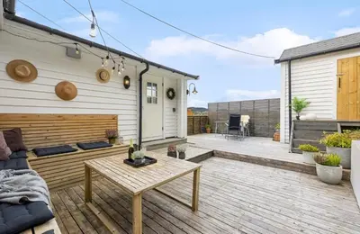 a patio with a couch and a table at Vestlandsidyll ved sjøen & Bergen