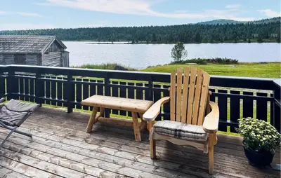 a wooden chair sitting on a deck with a view of a lake at 2 Bedroom Lovely Home In Nesbyen in Nesbyen
