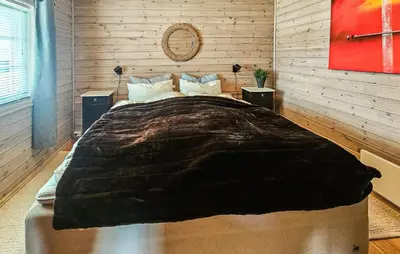 a bedroom with a large bed with a wooden wall at 2 Bedroom Lovely Home In Nesbyen in Nesbyen