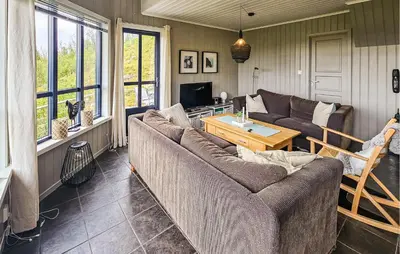 a living room with a couch and a table at Stunning Home In Edland With Sauna in Nesland