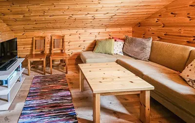 a living room with a couch and a table at Stunning Home In Edland With Sauna in Nesland