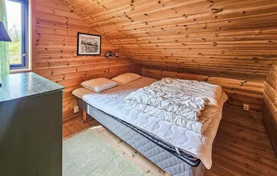 a bedroom with a bed in a wooden cabin at Stunning Home In Edland With Sauna in Nesland