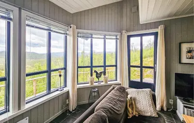 a living room with large windows and a couch at Stunning Home In Edland With Sauna in Nesland