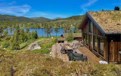 a house on a hill with a view of a lake at 4 Bedroom Nice Home In Vinje in Trovatn