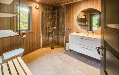 a bathroom with a shower and a toilet and a sink at 4 Bedroom Nice Home In Vinje in Trovatn