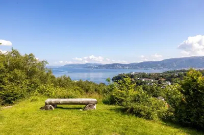 a bench sitting on top of a hill overlooking a lake at Large luxurious apartment with private terrace and parking in Bergen