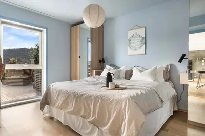 a bedroom with a large bed with a table on it at Large luxurious apartment with private terrace and parking in Bergen