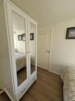 a bedroom with a large mirror and a bed at Cozy flat with lake view and 15 min from Bergen in Bergen