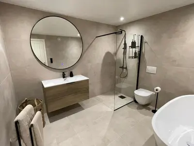 a bathroom with a sink and a mirror and a toilet at 2 leiligheter med panoramautsikt in Bergen