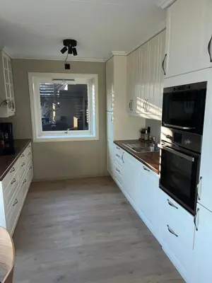 a kitchen with white cabinets and a window at 2 leiligheter med panoramautsikt in Bergen