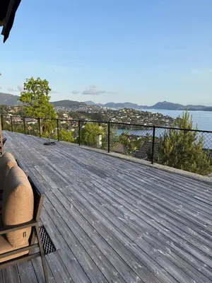a wooden deck with a view of the water at 2 leiligheter med panoramautsikt in Bergen