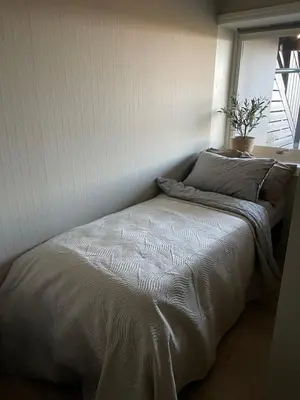 a small bed in a room with a window at 2 leiligheter med panoramautsikt in Bergen