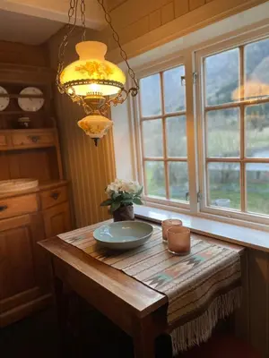 a dining room table with a chandelier and a plate on it at Arnestova - villagehouse in Loen in Loen