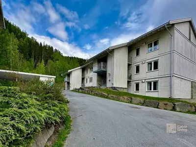 a row of buildings on the side of a road at Family friendly apartment in Hafjell ski in-out, fireplace, sauna and wifi in Hafjell
