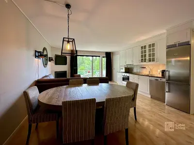 a kitchen and dining room with a table and chairs at Family friendly apartment in Hafjell ski in-out, fireplace, sauna and wifi in Hafjell
