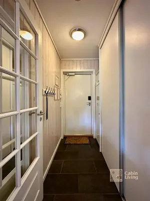 a hallway with a door and a tile floor at Family friendly apartment in Hafjell ski in-out, fireplace, sauna and wifi in Hafjell