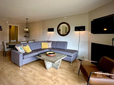 a living room with a blue couch and a table at Family friendly apartment in Hafjell ski in-out, fireplace, sauna and wifi in Hafjell