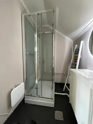 a glass shower in a bathroom with a sink at Small apartment with 4 bedrooms close to city in Trondheim