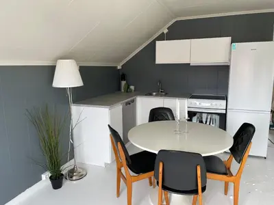 a kitchen with a table and chairs in a kitchen at Small apartment with 4 bedrooms close to city in Trondheim