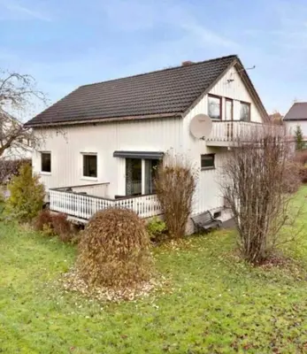 a white house with a porch and a yard at Small apartment with 4 bedrooms close to city in Trondheim