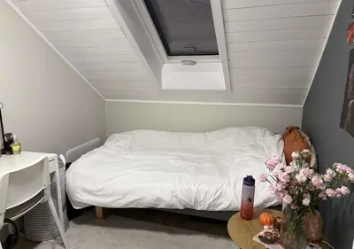 a small bedroom with a bed with a skylight at Small apartment with 4 bedrooms close to city in Trondheim