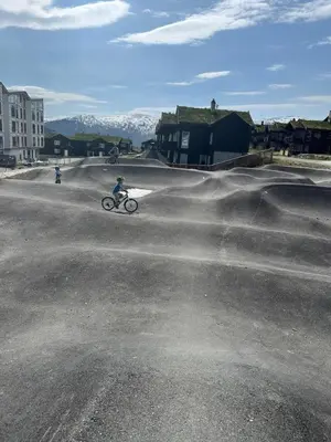 a person riding a bike in the middle of a street at Hytte sentralt i Myrkdalen in Vossevangen