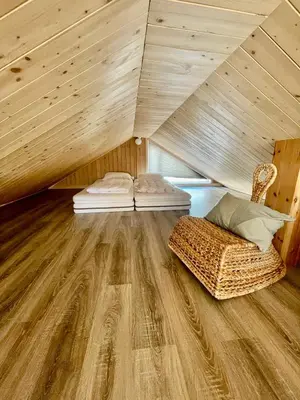 an attic room with two beds and a chair at Hytte sentralt i Myrkdalen in Vossevangen