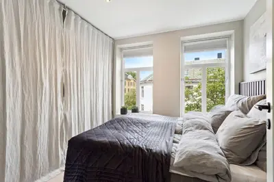 a bedroom with a bed and a large window at Apartment Lademoen Trondheim in Trondheim