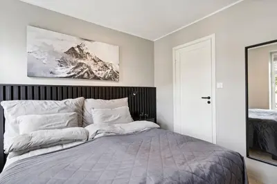 a bedroom with a bed with a picture on the wall at Apartment Lademoen Trondheim in Trondheim