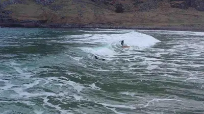 a person riding a wave on a surfboard in the water at Stavetunet in Stadlandet