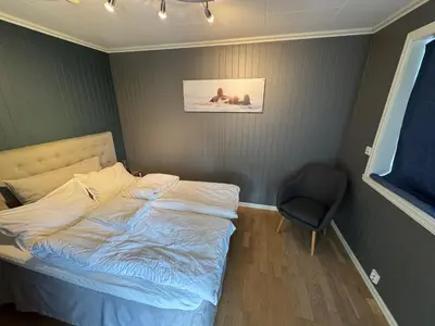 a small bedroom with a bed and a chair at Stavetunet in Stadlandet