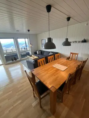 a dining room with a wooden table and chairs at Apartment Øvre Tråstølen - Voss in Vossevangen