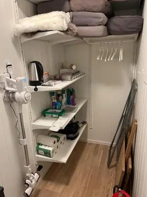 a closet with white shelves and a bed at Apartment Øvre Tråstølen - Voss in Vossevangen