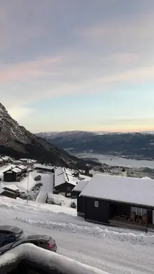 a snow covered town with a building and a road at Apartment Øvre Tråstølen - Voss in Vossevangen