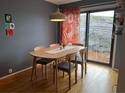 a dining room with a table and chairs and a window at The house next to the fjord in Trondheim