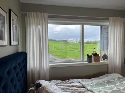 a bedroom with a bed and a large window at The house next to the fjord in Trondheim
