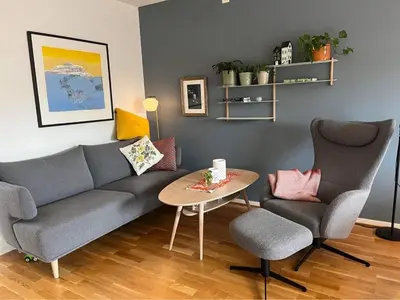 a living room with a couch and two chairs and a table at The house next to the fjord in Trondheim