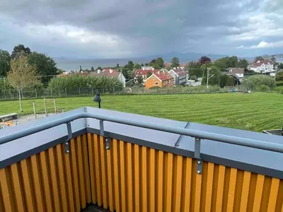a view of a field from a balcony at The house next to the fjord in Trondheim