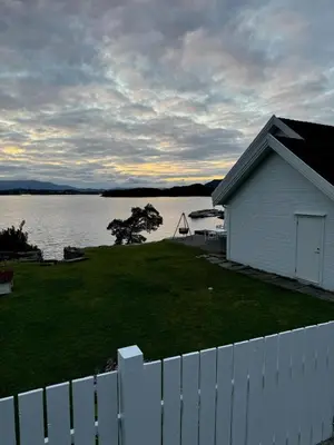 a white fence and a white house with a white picket fence at Gorgeous views and sunsets in Halsnøy, Kvinnherad in Ådnavik