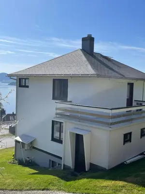 a white house with a roof on top of it at Retro hus med fin beliggenhet in Haddal