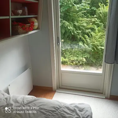 a bedroom with a door open to a garden at Markhus Apartment Near Langfoss in Markhus