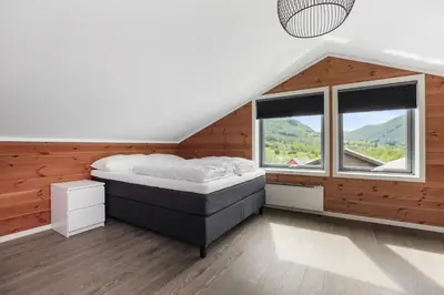 a bedroom with a bed in a room with windows at Large nice apartment in Myrkdalen in Vossevangen