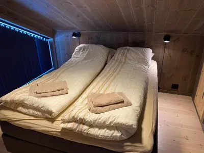 a bed in a room with two towels on it at New Apartment, Porch & Sauna, Sunnmøre Alps in Stranda