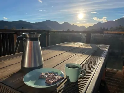 a table with a cup of coffee and a plate of food at New Apartment, Porch & Sauna, Sunnmøre Alps in Stranda