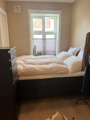 a bed in a bedroom with a window at Modern central apartment in a quiet area in Bergen