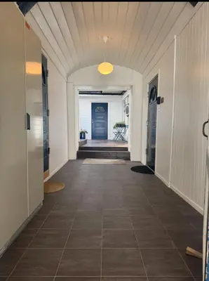 a hallway with a tile floor and a blue door at Modern central apartment in a quiet area in Bergen